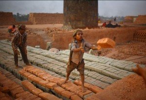 Enfant indien réceptionnant une brique - © Nick Hopton children-work-brick-factory-c-Nick-Hopton