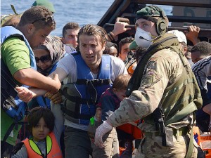 The sailors and Royal Marines of HMS Bulwark help migrants ashore. Picture by Royal Navy Media Archiv  Carl Osmond